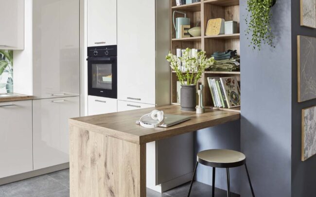 Modern kitchen from the Focus range with ultra high gloss cabinets in Alpine white, showcasing a cosy workspace and wooden elements. German kitchens at trade prices